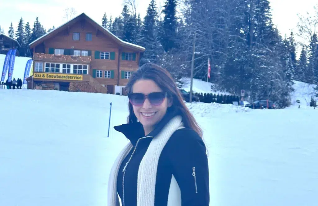 Moriya Rockman in the alps. Near a chalet in the snow.