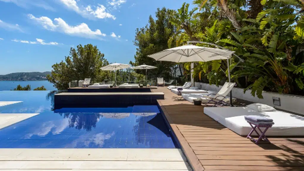 A pool with umbrellas and chairs
